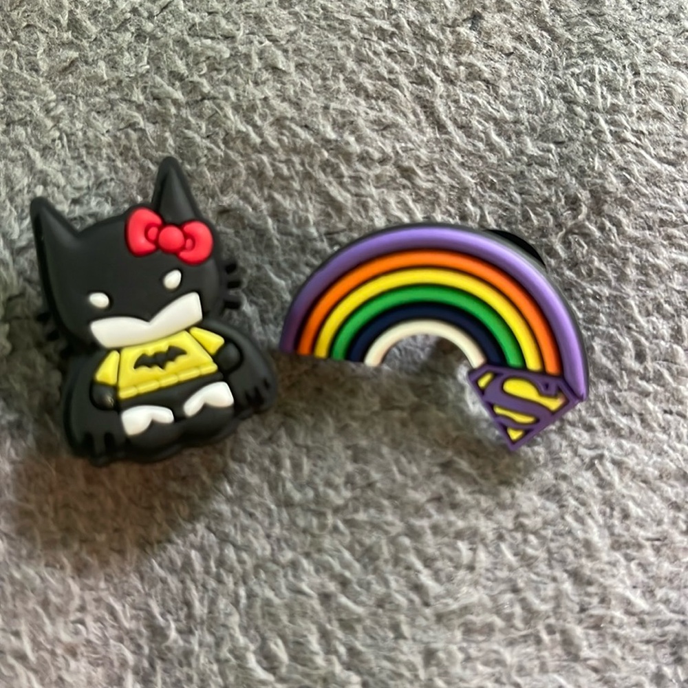 Hello Kitty, dressed as bat girl Batman, rainbow Supergirl, Superman, Croc charm